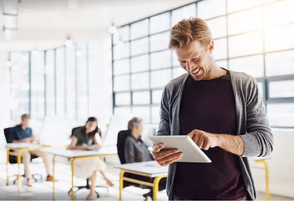 happy-employee-using-his-tablet-in-the-office