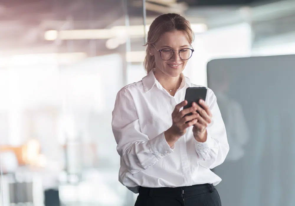 woman in office looking-at-digital-documents on mobile phone