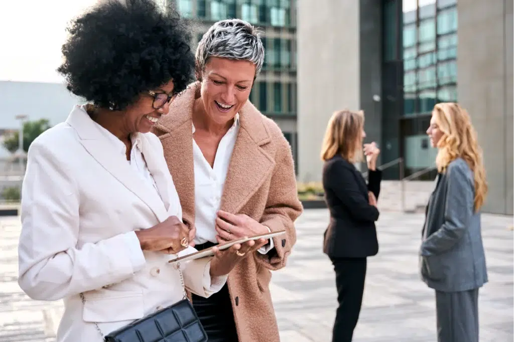 partners collaborating outdoors on tablet